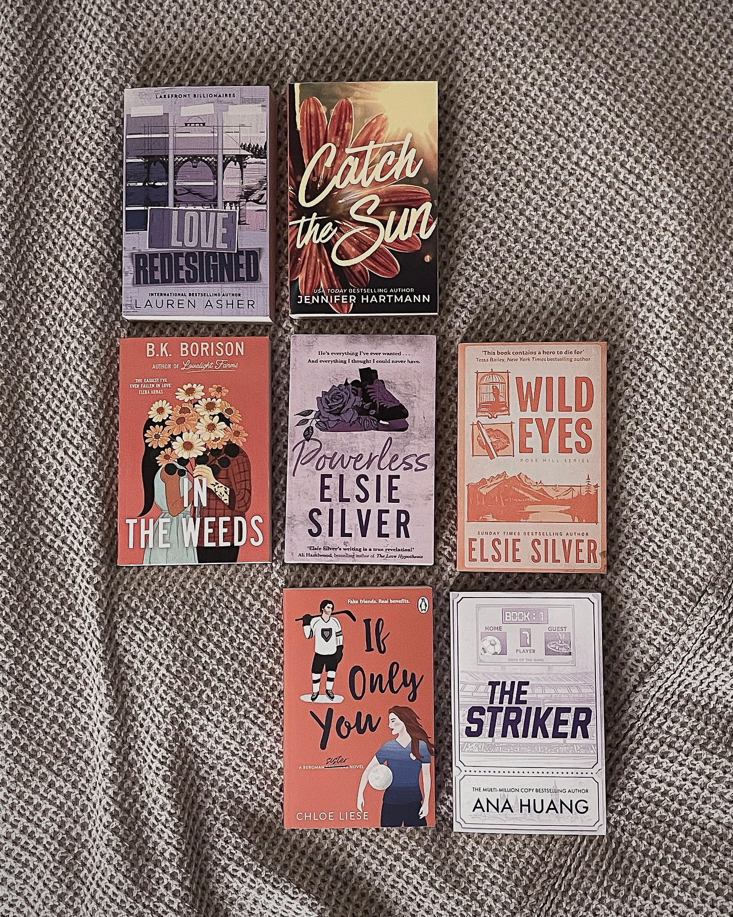 Purple and orange books lying flat on a throw